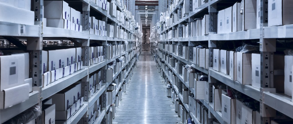 Interior of the new and modern warehouse space in a well lit large room. Rows of shelves with boxes
