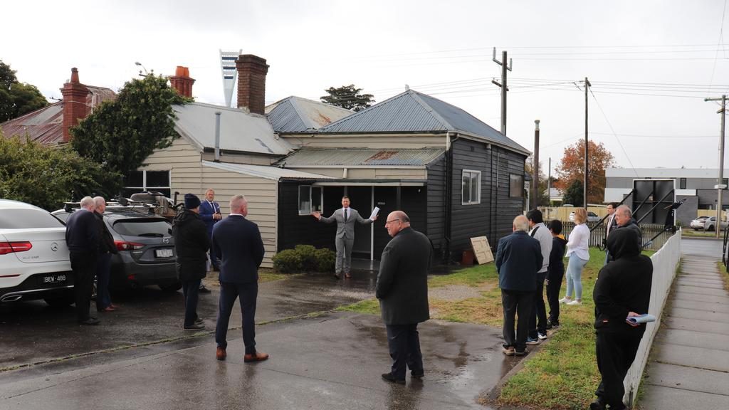 Auctioneer David Cortous calls for bids at 452, 454-456 La Trobe Tce, Newtown. The property sold after auction for $1.2 million.
