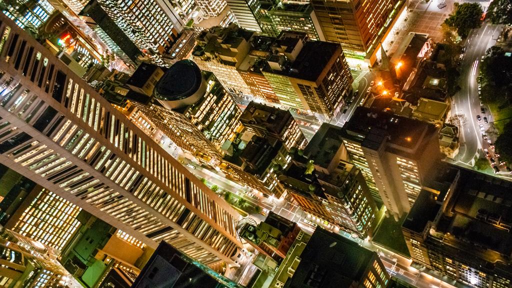A high view point looking down on the illuminated buildings of a modern city at night