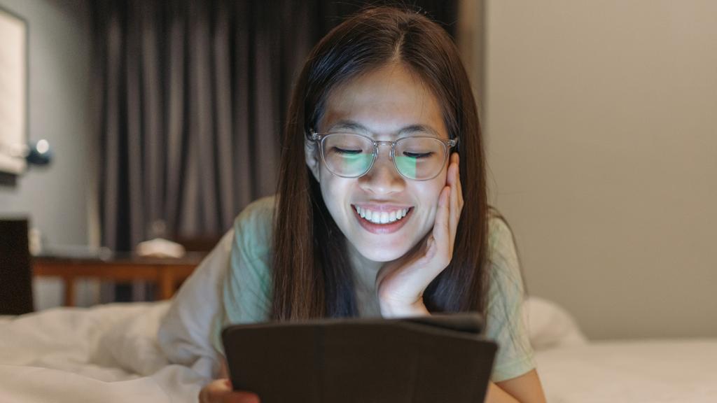 Millennial and Gen Z asia online investing in the stock market and cryptocurrencies in her home