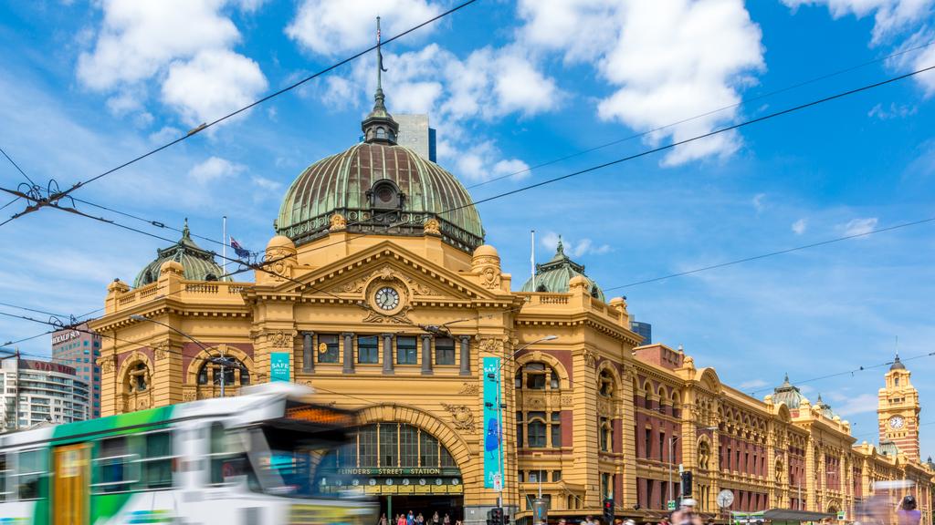 Melbourne, Australia- February 14, 2013: Pedestrians and cylers at the iconic Flinders Street Station in Melbourne, Australia