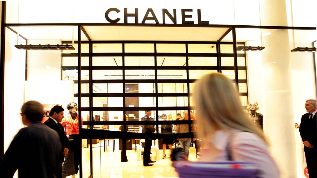 Shoppers walk past a Channel shopping mall store in Westfield Bondi Junction shopping mall in Sydney.